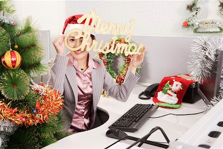 Office woman holding a sign of Merry Christmas on Christmas Day Stock Photo - Premium Royalty-Free, Code: 642-01733555