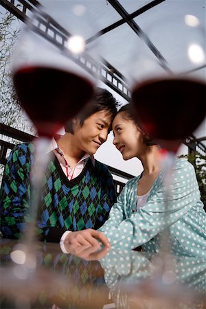 simsearch:642-01737214,k - Young couple sitting together with wineglasses in the foreground Stock Photo - Premium Royalty-Free, Code: 642-01733637