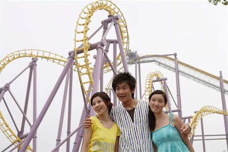 family in theme park - Young friends at amusement park, smiling Stock Photo - Premium Royalty-Free, Code: 642-01733830