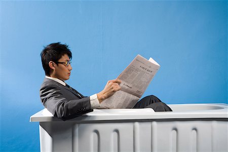 a business man sitting in the bath and reading the newspaper Stock Photo - Premium Royalty-Free, Code: 642-02005927