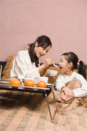 mother and her daughter taking food Stock Photo - Premium Royalty-Free, Code: 642-02006160