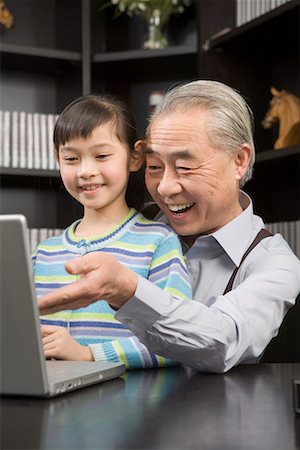 a girl and her grandpa playing the computer Stock Photo - Premium Royalty-Free, Code: 642-02006187