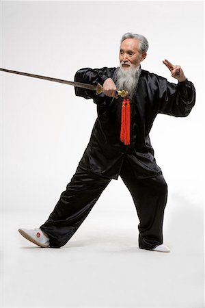 an old man practicing a Chinese sword Stock Photo - Premium Royalty-Free, Code: 642-02006512
