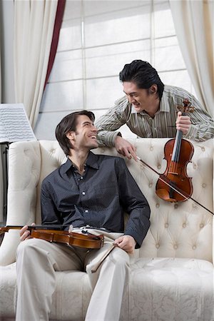 friends talking sofa and two people - a western man and an eastern man with violins in their hands Stock Photo - Premium Royalty-Free, Code: 642-02006576