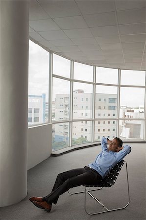 Singapore, Businessman sitting in chair in empty office Stock Photo - Premium Royalty-Free, Code: 655-08356893