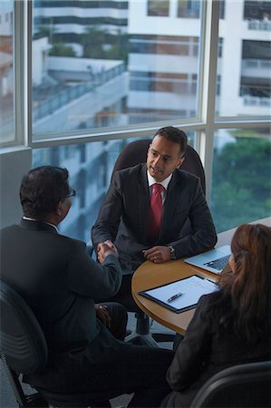 singapur - Singapore, Woman looking at two businessmen shaking hands Stock Photo - Premium Royalty-Free, Code: 655-08356960