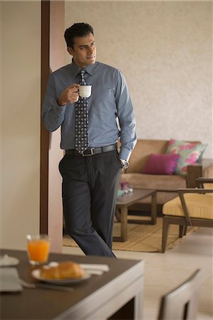 simsearch:655-08357168,k - India, Businessman standing in doorway with coffee cup and breakfast table Photographie de stock - Premium Libres de Droits, Code: 655-08356983