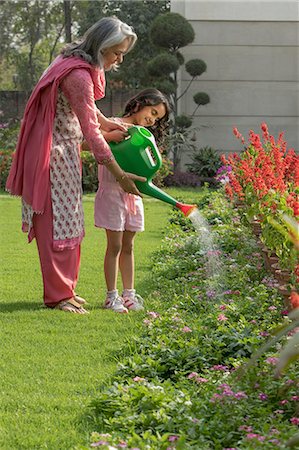 flower bed grass - Grandmother and grand daughter (4-5) using watering can in garden Stock Photo - Premium Royalty-Free, Code: 655-08357035