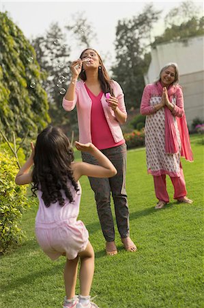 Mother blowing bubbles in garden with daughter (4-5) and grandmother Photographie de stock - Premium Libres de Droits, Code: 655-08357037