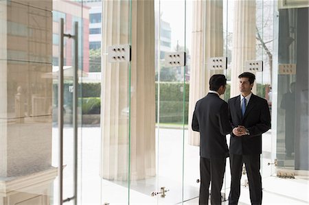 simsearch:655-08357080,k - India, Businessmen talking in building lobby Stock Photo - Premium Royalty-Free, Code: 655-08357079