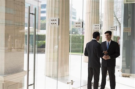 simsearch:655-08357080,k - India, Businessmen talking in building lobby Stock Photo - Premium Royalty-Free, Code: 655-08357080