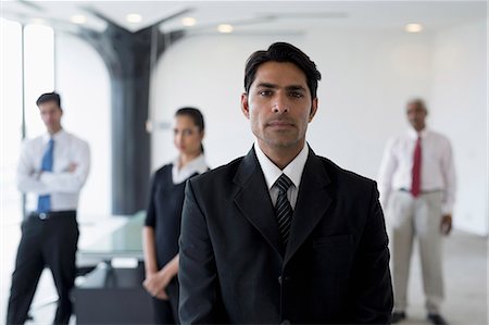 simsearch:655-08357113,k - India, Business man in suit standing in front of colleagues Fotografie stock - Premium Royalty-Free, Codice: 655-08357093