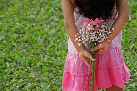 Une petite fille détient fleurs derrière son dos Photographie de stock - Premium Libres de Droits, Code: 655-01781354