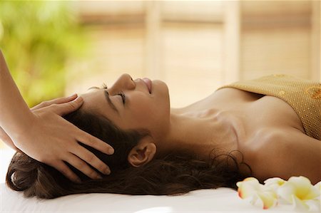 A woman lying down with frangipani flowers around her Stock Photo - Premium Royalty-Free, Code: 655-01781436