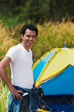 Young man camping smiling at camera Stock Photo - Premium Royalty-Free, Code: 655-01781516