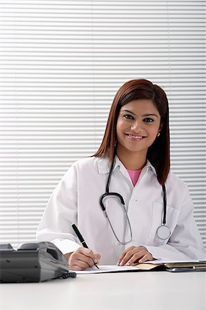 simsearch:655-02375854,k - Smiling doctor working with report Stock Photo - Premium Royalty-Free, Code: 655-02375818