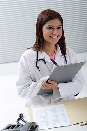 simsearch:655-02375854,k - Doctor smiling with report in hand Stock Photo - Premium Royalty-Free, Code: 655-02375833