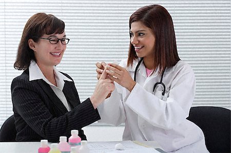 doctors group smiling - Doctor applying bandage to patient's finger Stock Photo - Premium Royalty-Free, Code: 655-02375848