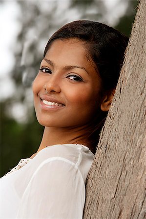 woman leaning on tree, smiling Stock Photo - Premium Royalty-Free, Code: 655-02702885