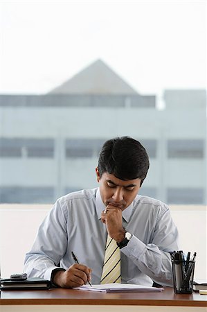 focused professional - business man writing at his work desk Stock Photo - Premium Royalty-Free, Code: 655-02702896
