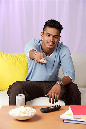 single man on the couch watching tv - young man with television remote Stock Photo - Premium Royalty-Free, Code: 655-02703057