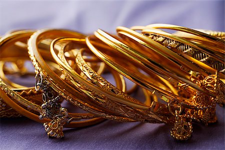 extravagance - gold Indian bangles on purple sari cloth Foto de stock - Sin royalties Premium, Código: 655-02703059
