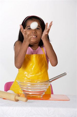 simsearch:655-02883054,k - Girl baking, tossing egg Foto de stock - Royalty Free Premium, Número: 655-02883042