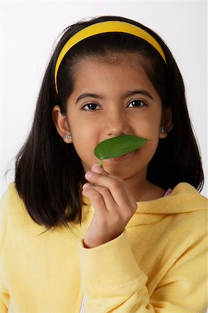simsearch:655-02883054,k - Girl smelling green leaf Foto de stock - Royalty Free Premium, Número: 655-02883052