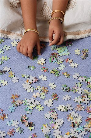 puzzle pieces hand - Hands of little girl working on puzzle Stock Photo - Premium Royalty-Free, Code: 655-02883060