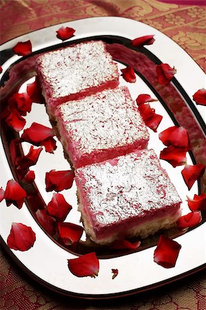 simsearch:656-03076249,k - Desserts roses Indiens sur un plateau argenté avec pétales de rose Photographie de stock - Premium Libres de Droits, Code: 655-03082811