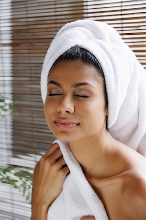 Indian woman closing her eyes relaxing with towel on her head Foto de stock - Royalty Free Premium, Número: 655-03241607