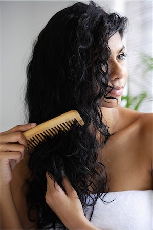 eurasian - Indian woman with bare shoulders and combing her hair. Stock Photo - Premium Royalty-Free, Code: 655-03241621
