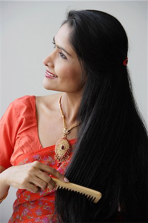 simsearch:655-02375891,k - Indian woman smiling while combing hair Foto de stock - Royalty Free Premium, Número: 655-03241639