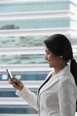 singapore window - Profile of Indian woman looking at phone outside. Stock Photo - Premium Royalty-Free, Code: 655-03241654