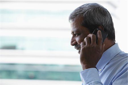 simsearch:655-03458024,k - Head shot of mature Indian man talking on phone Fotografie stock - Premium Royalty-Free, Codice: 655-03457916