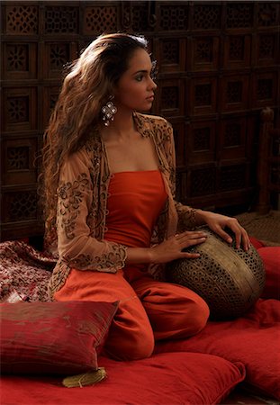 simsearch:614-08119697,k - Young woman relaxing on pillows with Indian antiques Fotografie stock - Premium Royalty-Free, Codice: 655-03457999