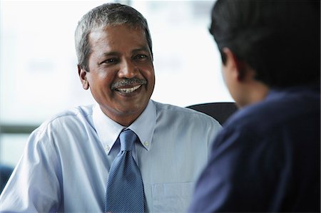 east indian businesspeople not studio not shopping not group not stress - Two businessmen smiling at each other Stock Photo - Premium Royalty-Free, Code: 655-03458001
