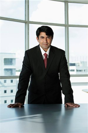 singapore window - Indian businessman standing behind desk Stock Photo - Premium Royalty-Free, Code: 655-03458037