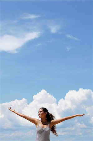 simsearch:655-03519580,k - happy young woman raising her arms, blue sky and clouds background. Stock Photo - Premium Royalty-Free, Code: 655-03519604