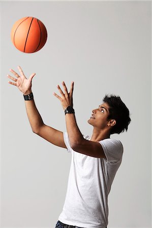 jeune homme jette le basket-ball dans l'air Photographie de stock - Premium Libres de Droits, Code: 655-03519663