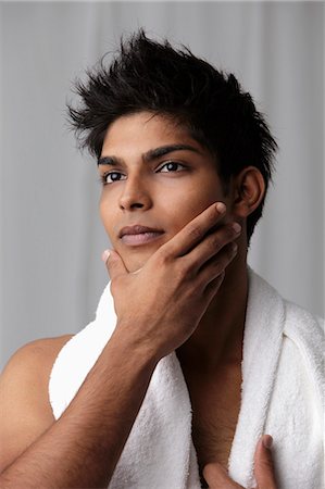 prep - Young man feeling his chin with towel around his neck Stock Photo - Premium Royalty-Free, Code: 655-03519679