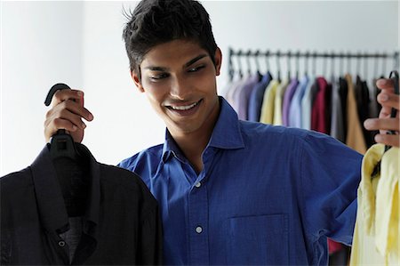 young man deciding between two shirts Stock Photo - Premium Royalty-Free, Code: 655-03519693