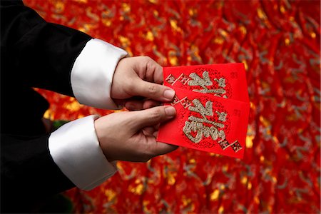 Cropped shot of man holding lucky Hong Bao, red envelope Stock Photo - Premium Royalty-Free, Code: 656-04926470