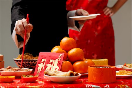 Crop shot of someone getting food during Chinese New Year party. Stock Photo - Premium Royalty-Free, Code: 656-04926538
