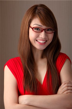 Jeune femme en robe rouge et portant des lunettes rouges Photographie de stock - Premium Libres de Droits, Code: 656-04926561