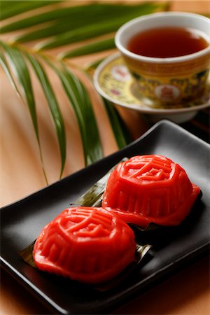 singapore food - Ang Ku Kueh. Glutinous rice cake with tea. Chinese character for "sweet" on the top. Foto de stock - Sin royalties Premium, Código: 656-04926595