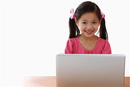 Young Chinese girl playing on laptop Foto de stock - Sin royalties Premium, Código: 656-04926596