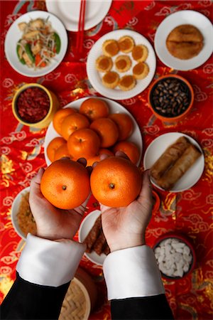 singapore food - Hands holding oranges over table with Chinese food Foto de stock - Sin royalties Premium, Código: 656-04926605