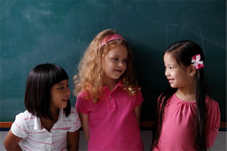 escuela primaria - three young girls smiling at each other Foto de stock - Sin royalties Premium, Código: 656-04926609