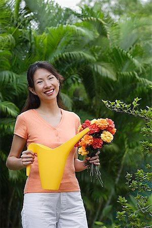 simsearch:6113-06499128,k - Woman in garden, holding bouquet of flowers and watering can Fotografie stock - Premium Royalty-Free, Codice: 656-01765245